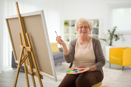 Happy Older Woman Holding A Paint Brush  - In Home Aged Care - ESP Healthcare